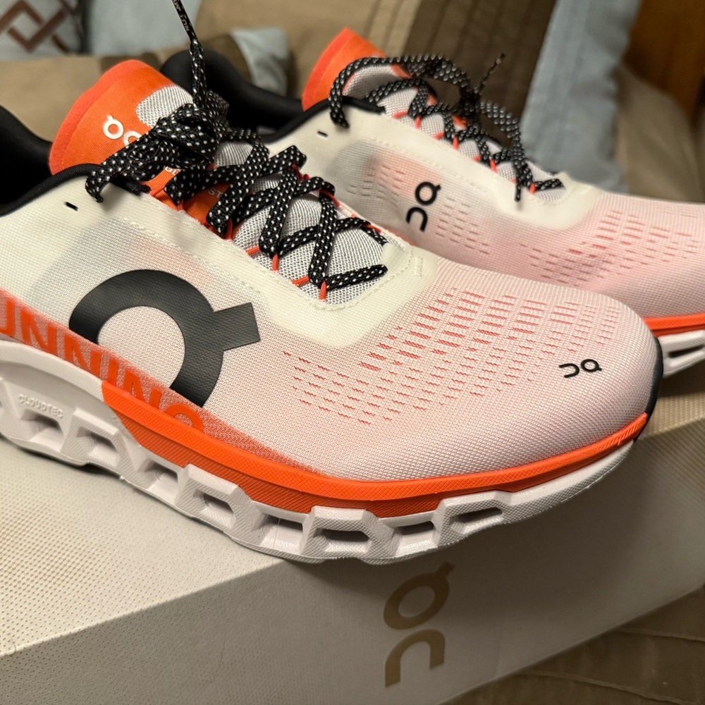 On Running White and Orange Athletic Shoes
